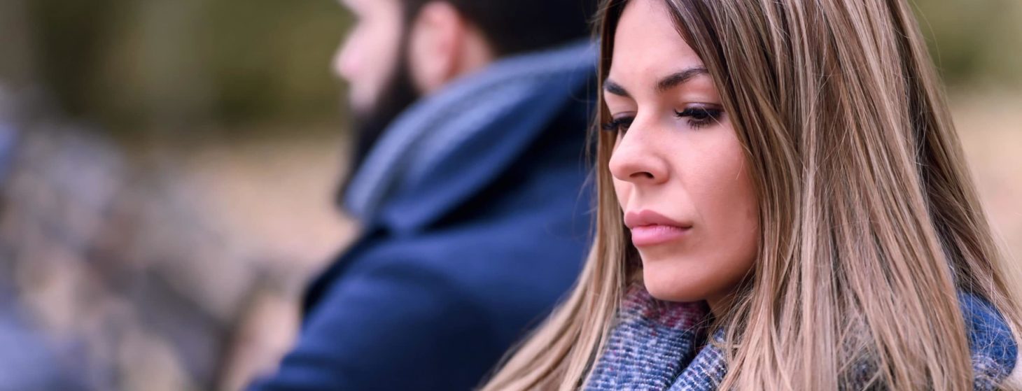 Couple sitting in park having relationship problems
