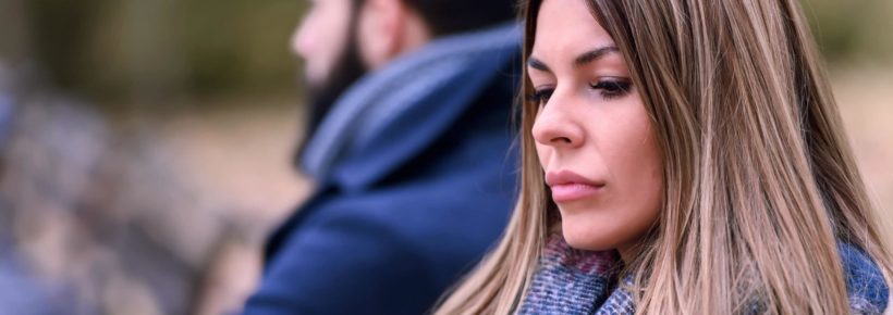 Couple sitting in park having relationship problems