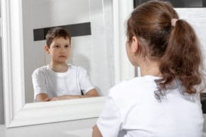 image of a girl with gender dysphoria looking in the mirror