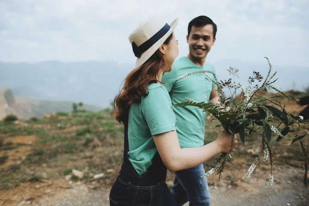 happy couple walking with flowers