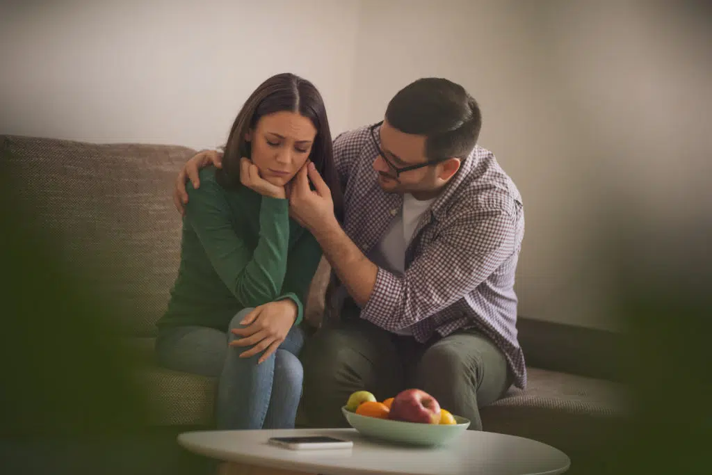 man consoling a sad woman
