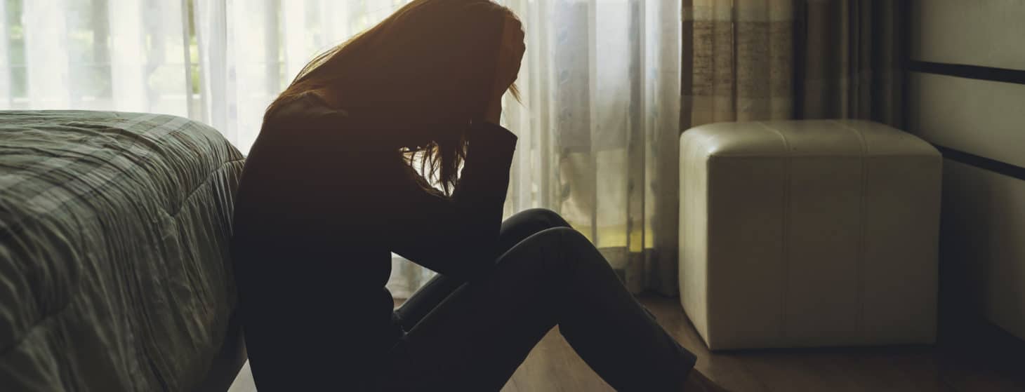 sad woman sitting in her bedroom