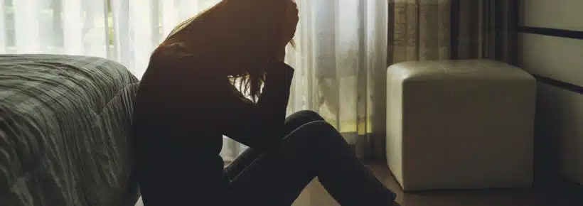 sad woman sitting in her bedroom