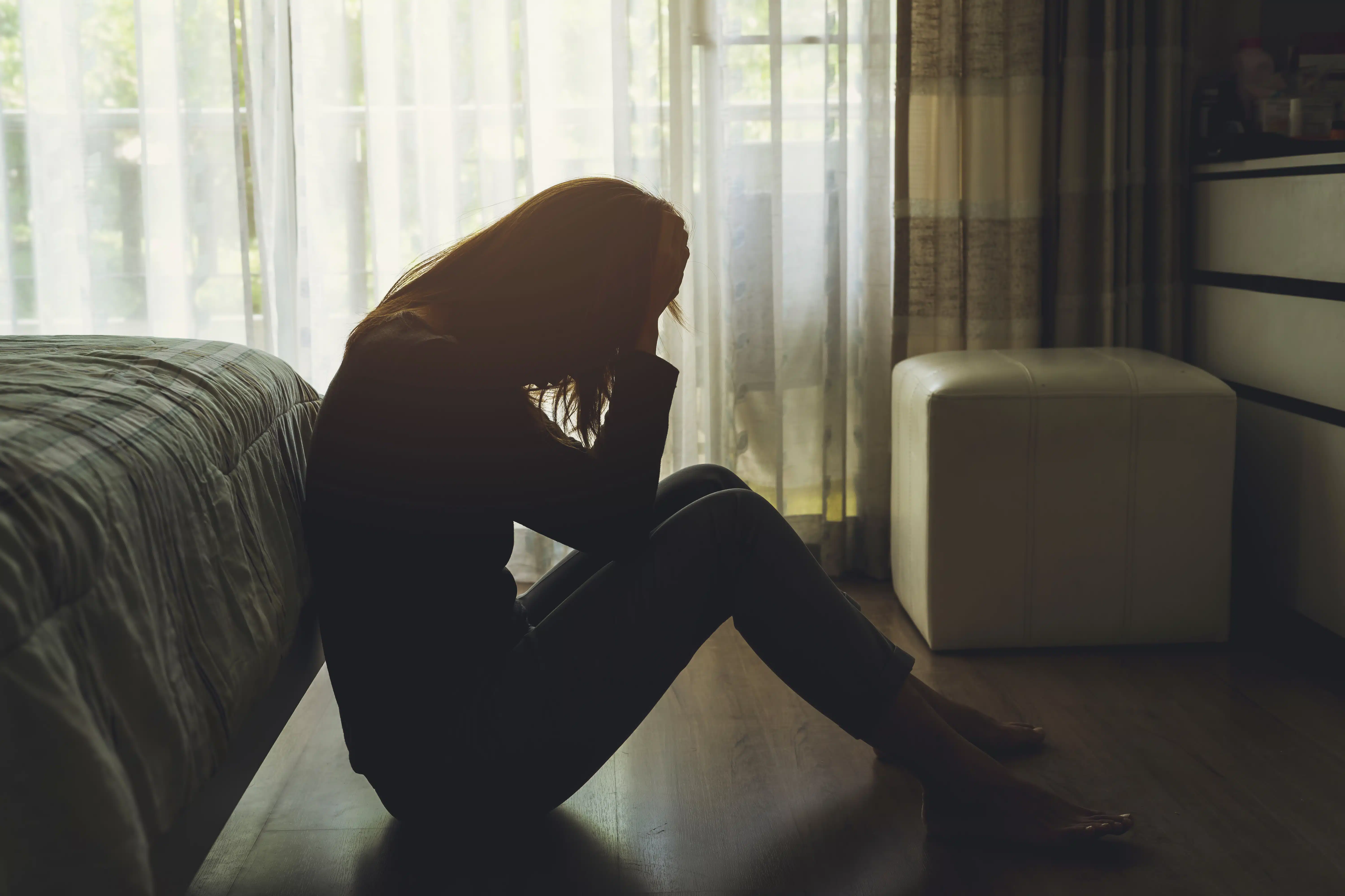 sad woman sitting in her bedroom