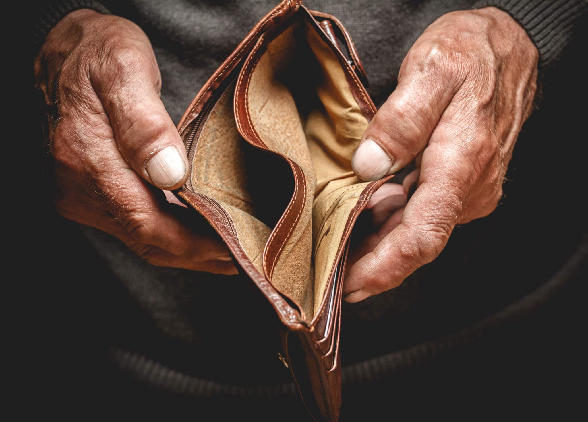 empty wallet in hands of elderly man