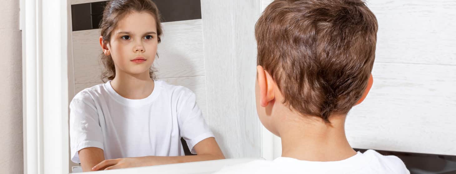 boy seeing a reflection of a girl in the mirror, concept of gender dysphoria