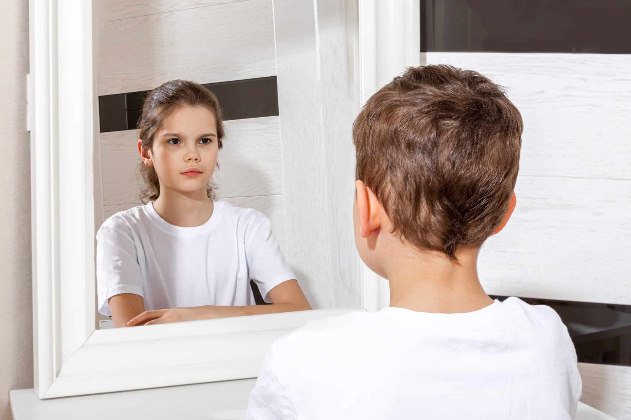 boy seeing a reflection of a girl in the mirror, concept of gender dysphoria