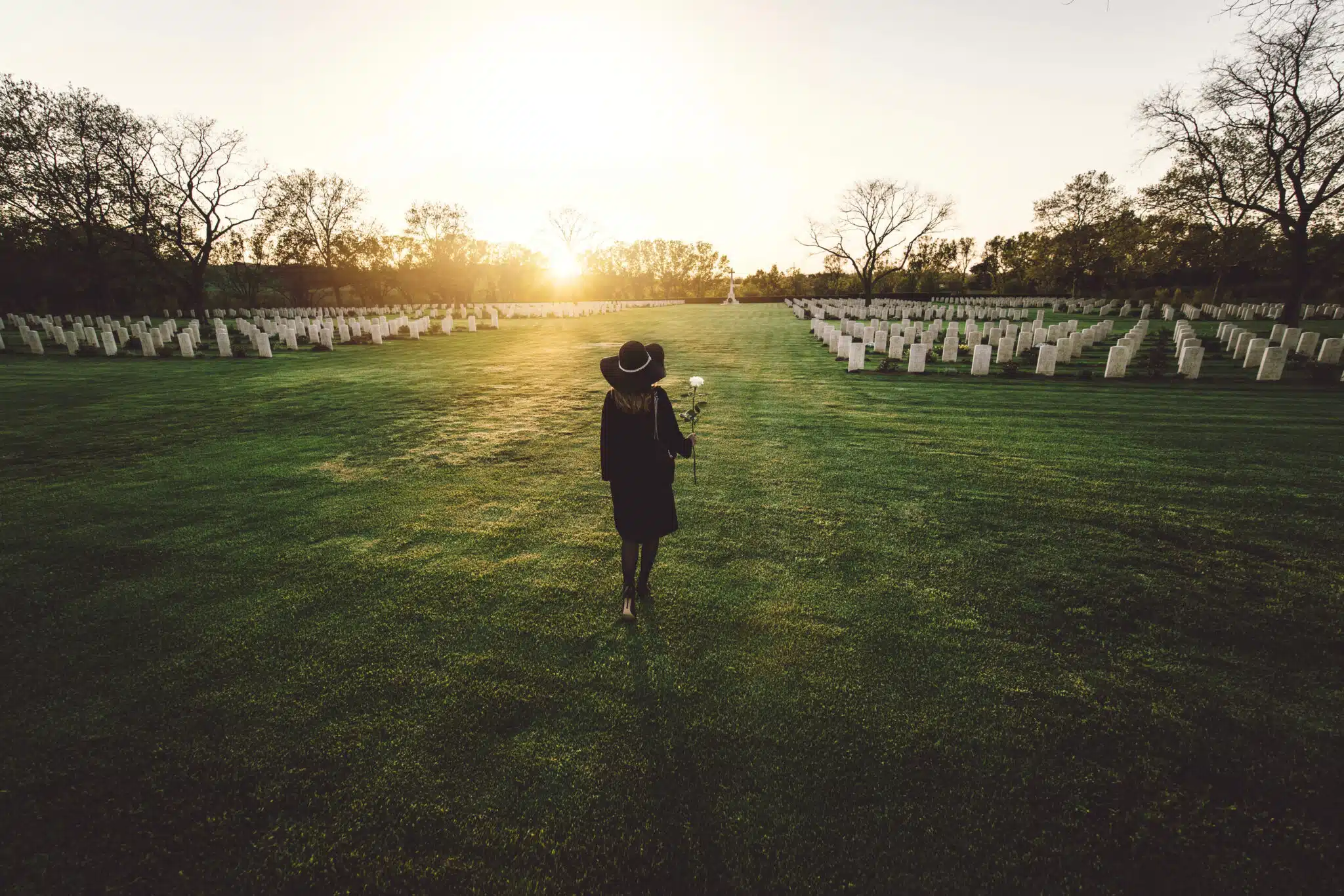 woman in black visiting cemetery grieving