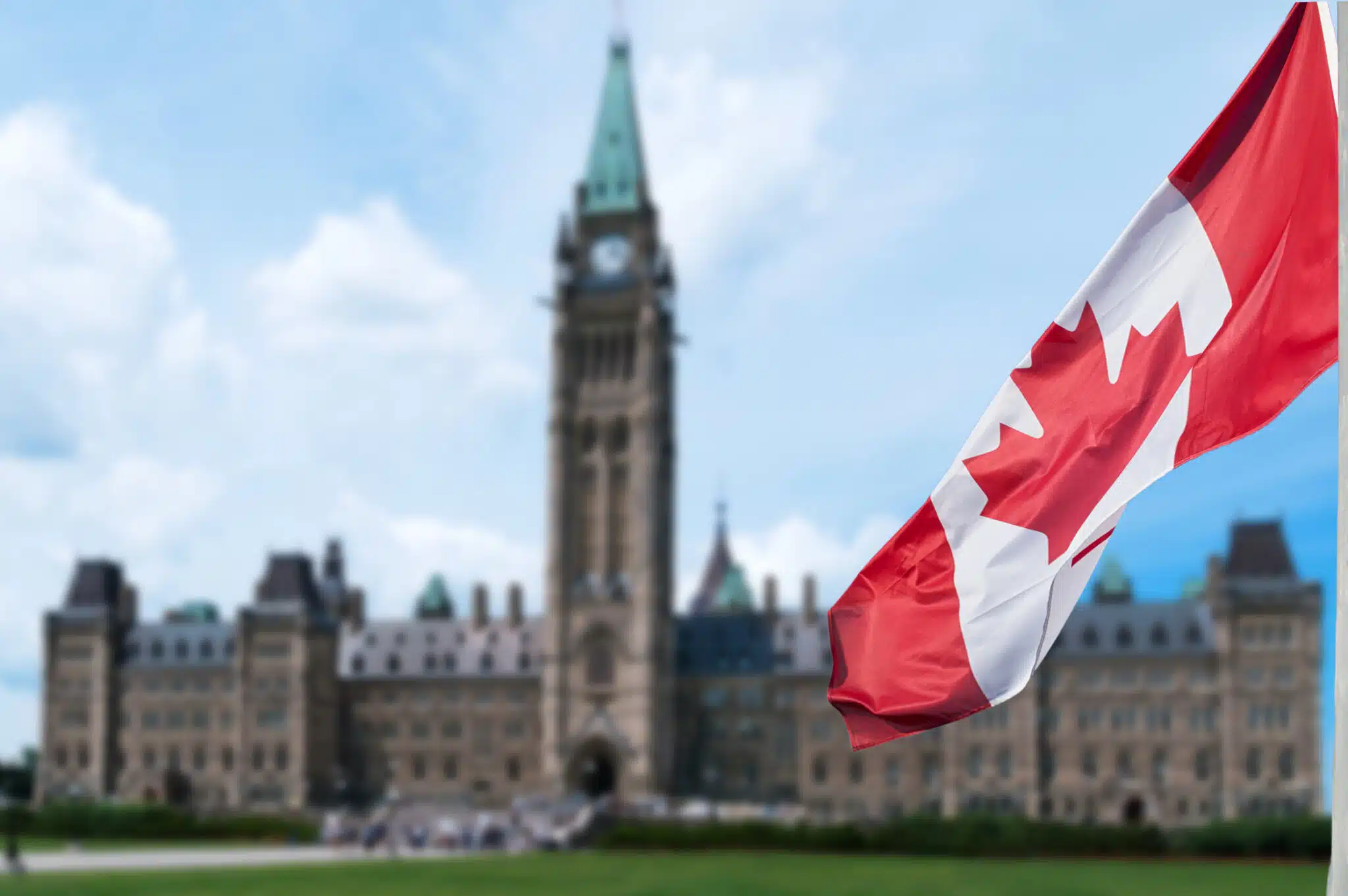 Canadian flag waving in front of Parliament