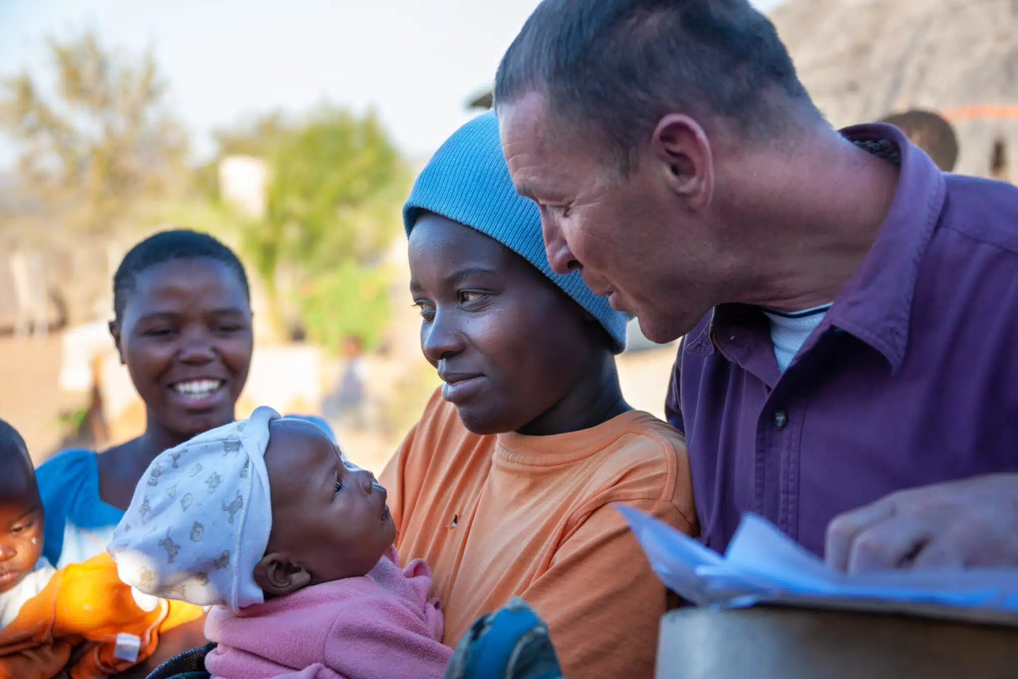 African women in village with a baby