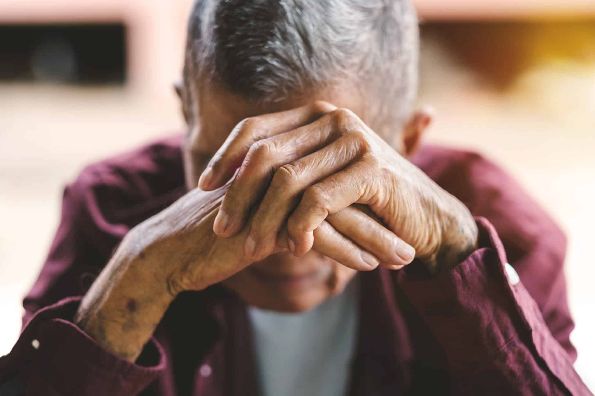 senior man covering his face
