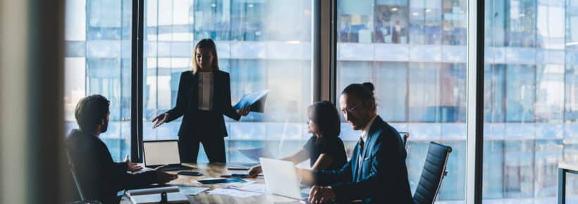 Clever male and female partners in formal wear collaborating on financial report for company sitting at desktop with modern technology and analyzing data information, concept of brainstorming