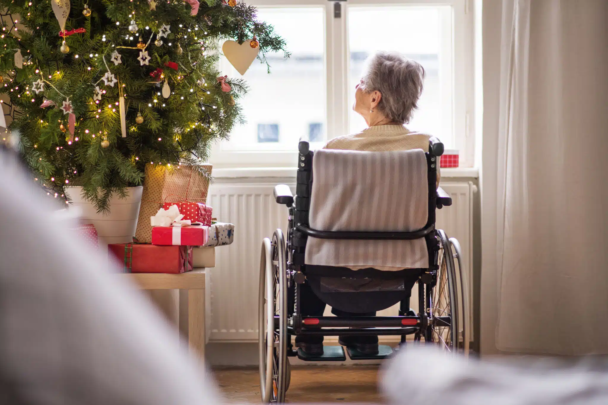 lonely senior women in wheelchair by christmas tree