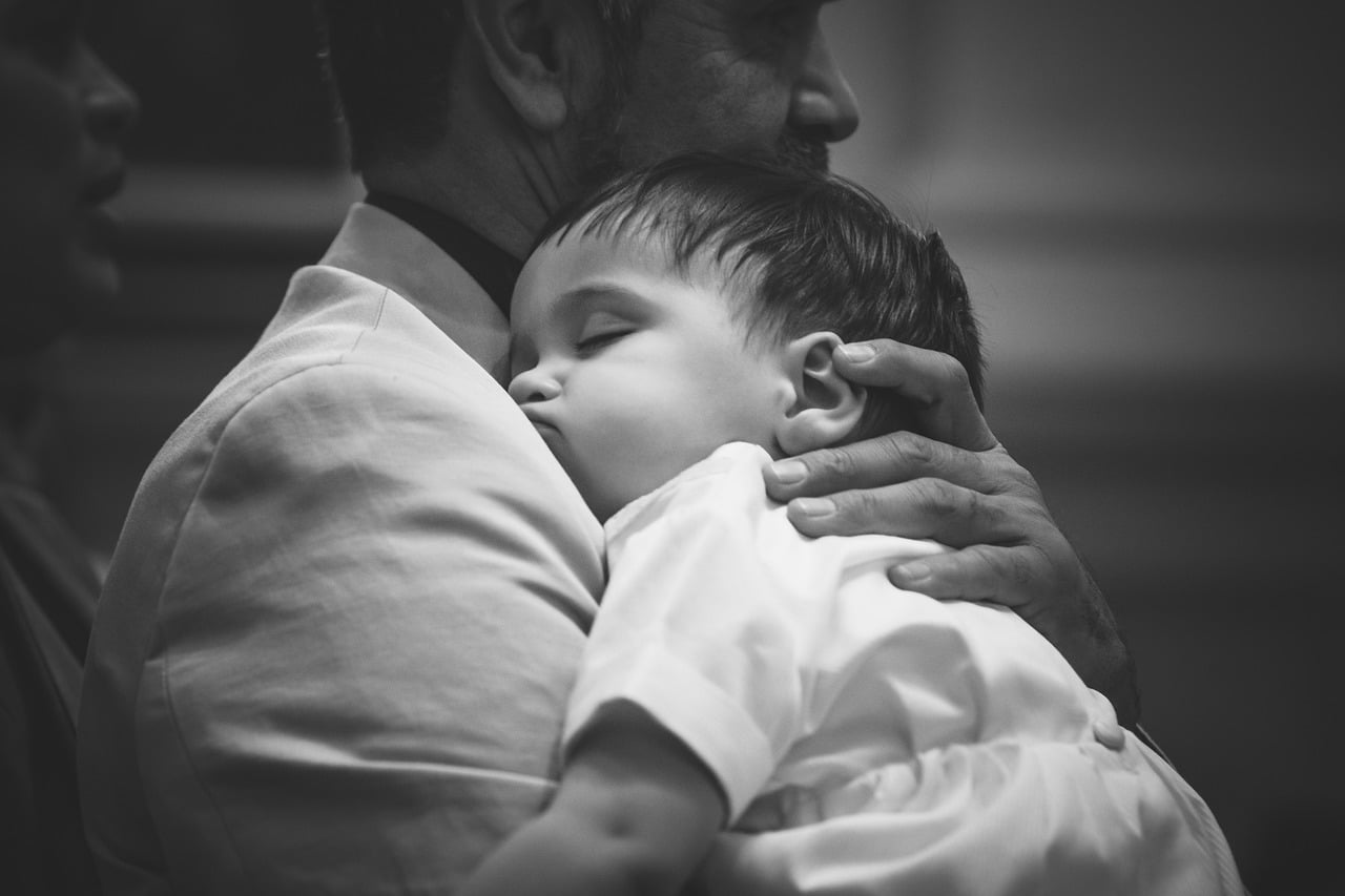 father holding baby in church