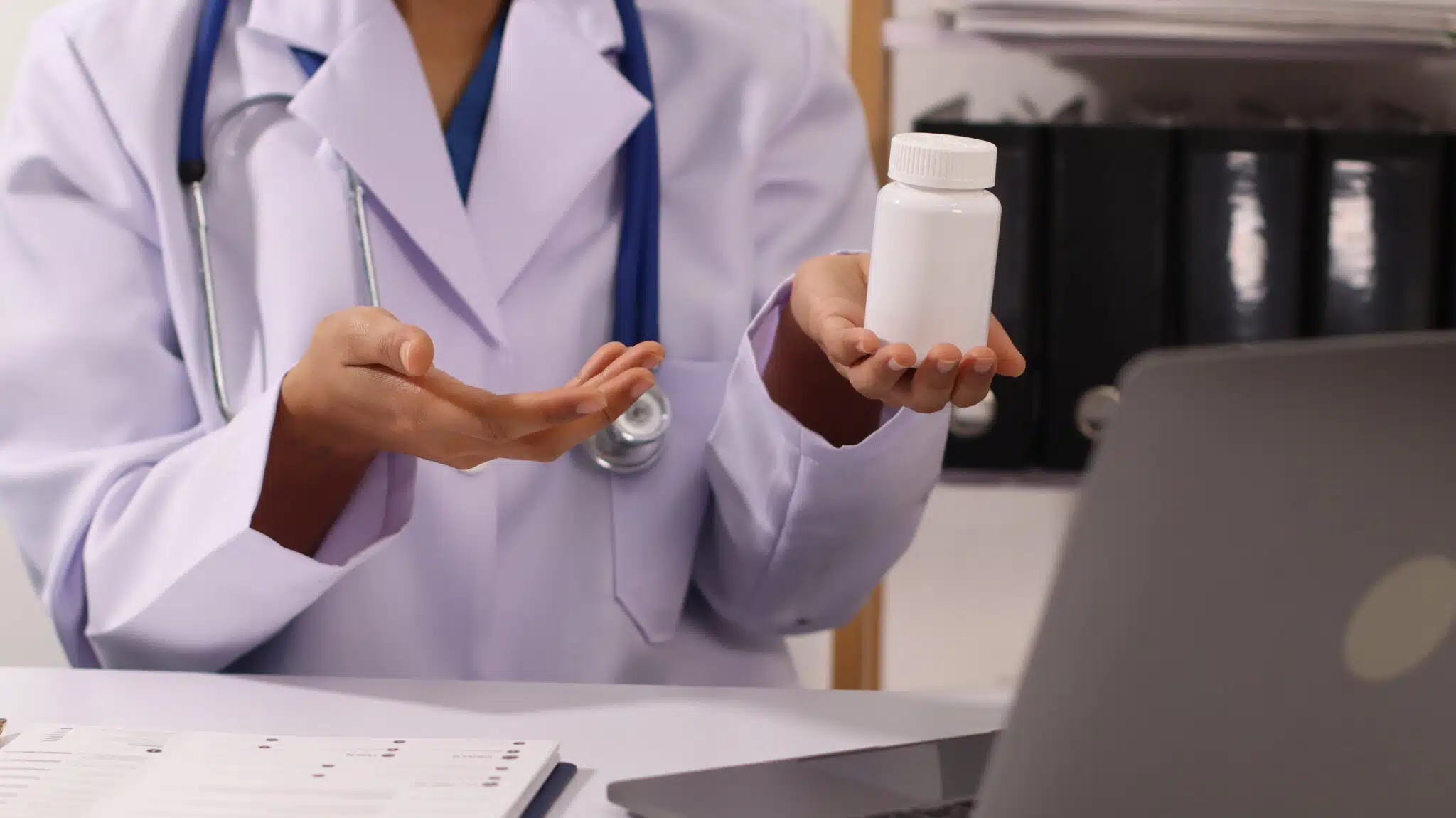 doctor holding bottle of pills